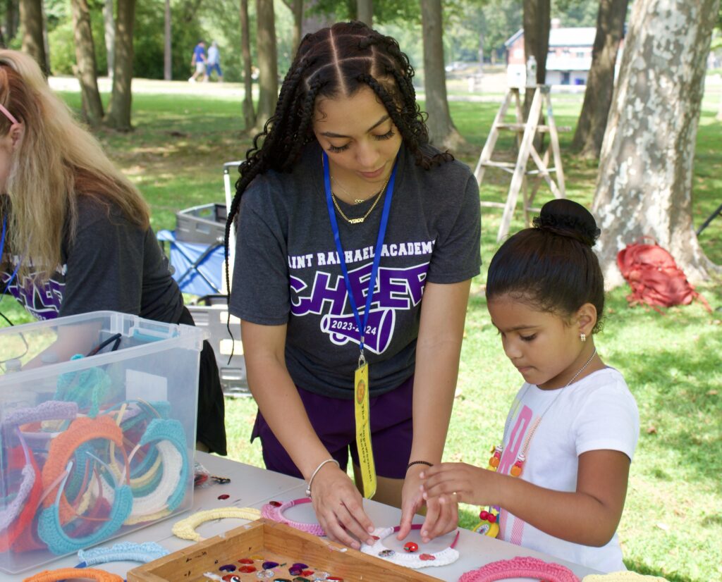 A photo of a volunteer helping a child at an Empowerment Factory Event