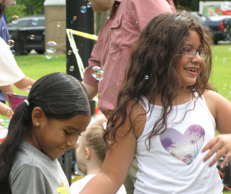 Two children with bubbles outside at the 8th Annual Healthy Living Community Event 2024