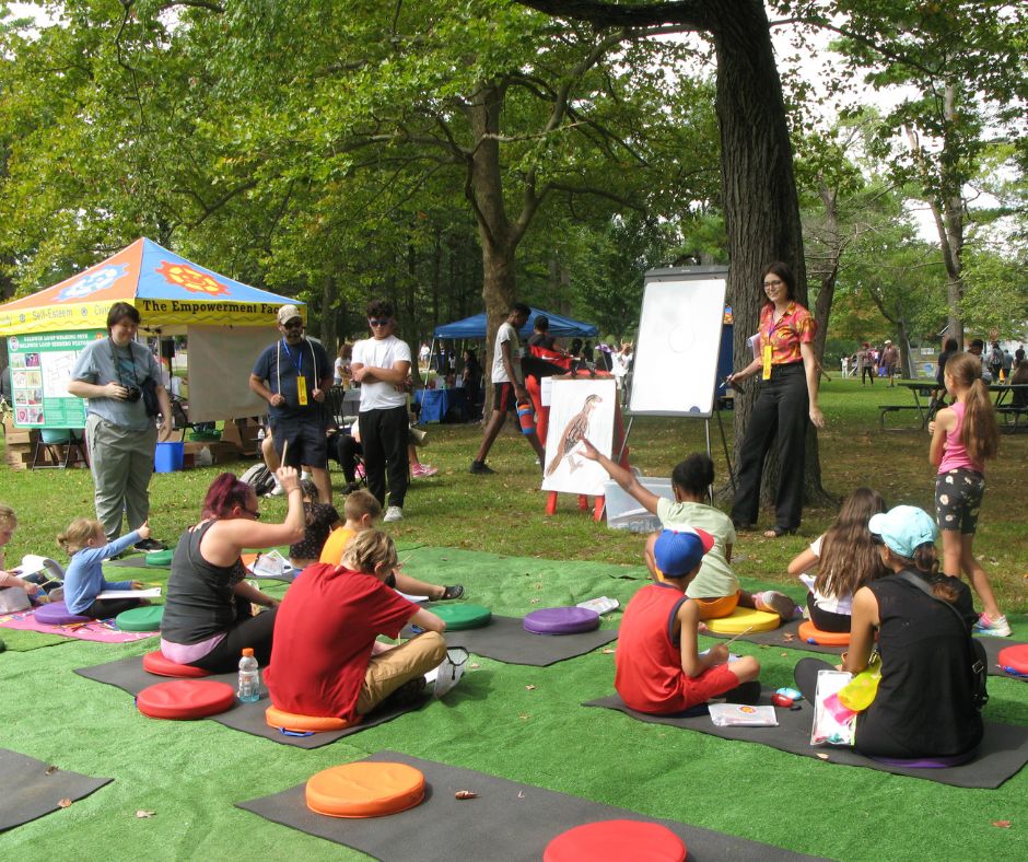 Julia teaching Nature Drawing to a group of children outside at 2024 HLCE